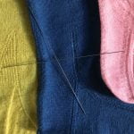yellow, blue, and pink stockings in detail with needles